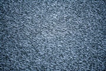 Water texture with raindrops. Raindrops background. Rain. Falling raindrops. Water drop splash. Abstract shape out of the water. Raining outside.