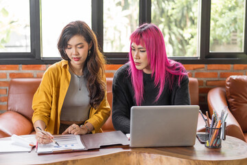 LGBTQ+ transgender man Beautiful Authentic Specialist with Pink Hair and Non-binary trans working together Working Design in creative workplace team work colleagues Gender equality