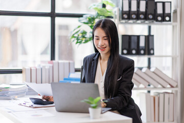 Happy busy young business woman entrepreneur in office using laptop at work, smiling professional asian female company executive manager working looking at computer at workplace.