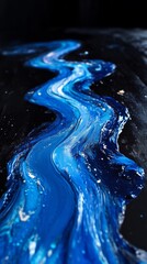 Flowing blue paint on dark surface, abstract