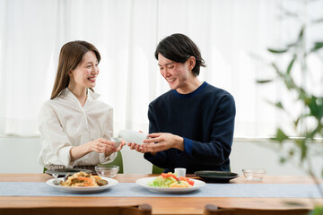 自宅でゆっくり昼食を楽しむ夫婦（ホームパーティ・おうち時間）