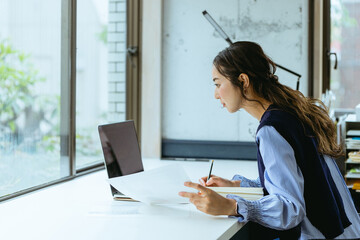 資料を手にして働く女性（自宅・テレワーク・オフィス）