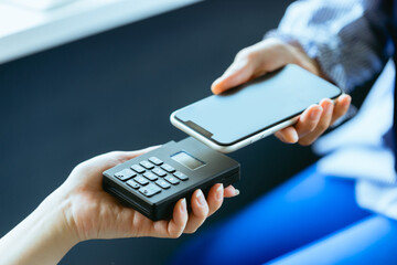 スマホ決済をする女性（手元・ボディパーツ・アップ）