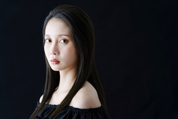 Fototapeta premium 黒バックの前に立つ女性