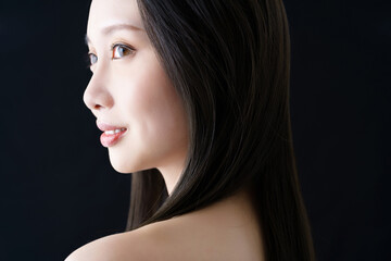 黒バックの前に立つ女性