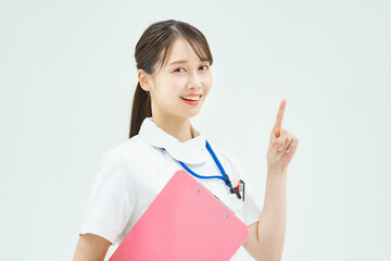 指を立てるポーズをする白衣の女性 