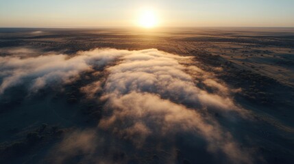 Fototapeta premium Aerial View of Fog Rolling Over Desert Landscape at Sunrise