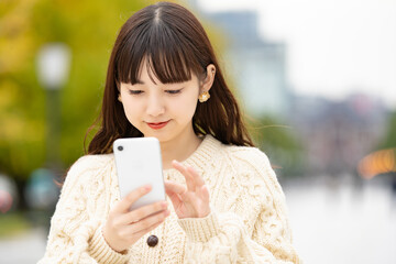スマートフォンを操作する女性