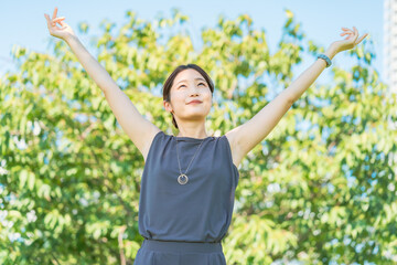 緑の中でリラックスする若い女性