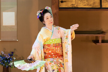 着物姿で扇子を持って日本舞踊を踊る年配の日本人女性