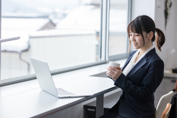 オフィスでコーヒーを飲む女性