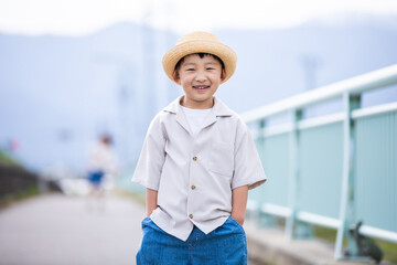 麦わら帽子をかぶった笑顔の男の子