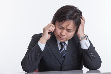 携帯電話で謝る男性