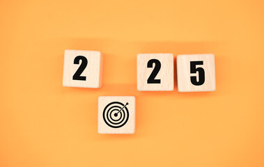 New year 2025 with 2025 wooden blocks on orange background. Start the new year 2025 with a goal plan. goal concept Action plan, strategy, new year business vision