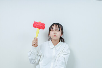 右手にハンマーを持ち目を閉じた女の子