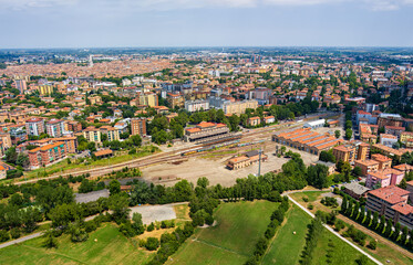 Modena, Italy. Train station - Modena Piazza Manzoni. Panorama of the city on a summer day. Sunny weather with clouds. Aerial view