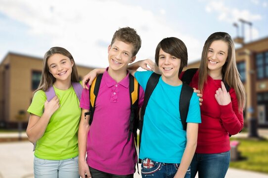 Group of happy schoolmates friends walking to school