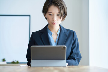 部屋で仕事をするスーツ姿の女性