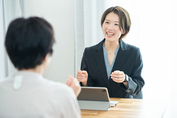 私服の女性に説明するスーツ姿の女性