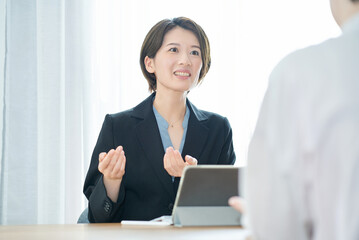 私服の女性に説明するスーツ姿の女性