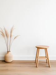 Minimalist interior design featuring a stool and decorative vase with pampas grass in a bright space