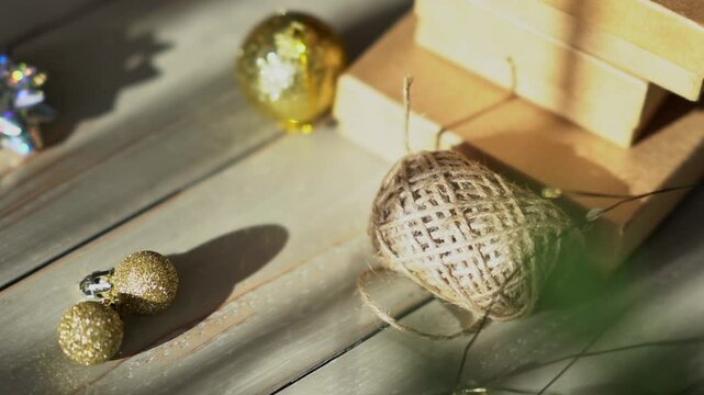 Holiday decor. Packing holiday gifts. Gift boxes, silver bow and Christmas gold balls against the backdrop of the Christmas tree and golden bokeh
