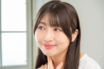 Obraz premium 鏡を見て肌を確認する女性
