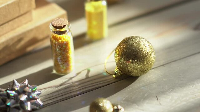 Holiday decor. Packing holiday gifts. Gift boxes, silver bow and Christmas gold balls against the backdrop of the Christmas tree and golden bokeh