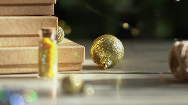 Holiday decor. Packing holiday gifts. Gift boxes, silver bow and Christmas gold balls against the backdrop of the Christmas tree and golden bokeh