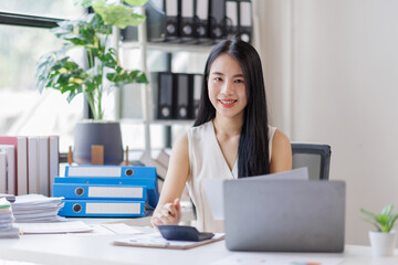 Young business asian woman working at office with documents on desk, doing planning analyzing the financial report, business plan investment, finance analysis concept	