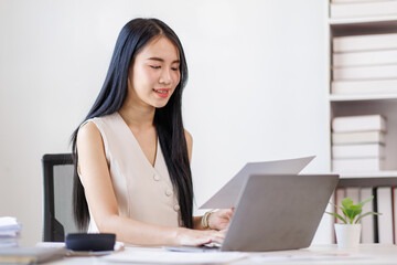 Young business asian woman working at office with documents on desk, doing planning analyzing the financial report, business plan investment, finance analysis concept	