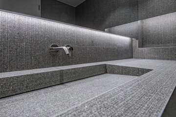 Restroom interior with dark gray tiles