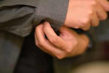 Fototapeta premium Closeup of a woman hands buttoning a shirt