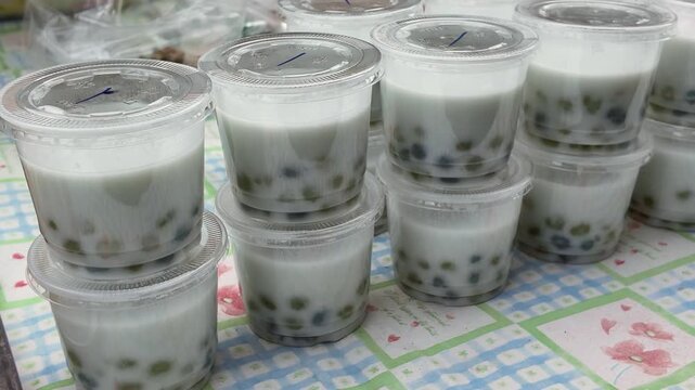 Sweet and Refreshing: Rows of Clear Cups Filled with Creamy Boba Tea, ready to satisfy your sweet tooth. A perfect visual for food blogs, social media, and beverage advertising.