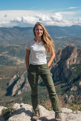 Naklejka premium Woman in a casual outfit hiking on a mountain peak, symbolizing strength and adventure