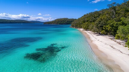 Obraz premium Crystal-clear turquoise water meeting the white sandy beach, framed by a vibrant horizon