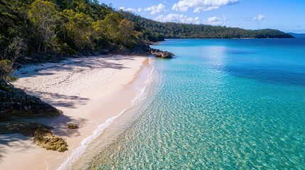Crystal-clear turquoise water meeting the white sandy beach, framed by a vibrant horizon