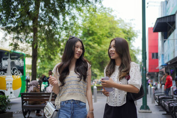 happy two asian women walking on the street