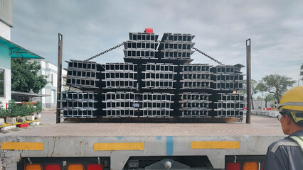 Metal profile beam in packs at the warehouse of metal products.Steel I-beam,Flange beam in warehouse,steel beams placed outside on a steel rack,steelwork,Structural steel