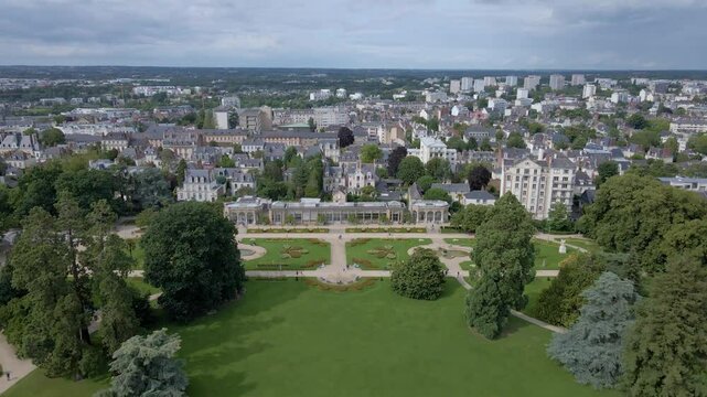 Amazing panoramic drone movement backwards towards the botanical garden of Parc du Thabor and citsycape, Rennes, Bretagne in France.