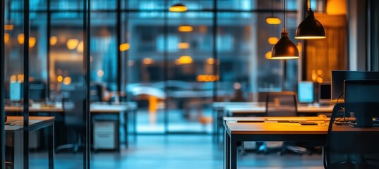 Obraz premium Modern Office Interior with Sleek Desks, Bright Ambient Lighting, and Large Windows Overlooking Urban Cityscape at Dusk