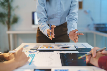 Team of business people working together in a conference room, planning, analyzing Calculating graph cost, profit, turnover. Successful teamwork, business planning concept.