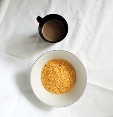 cup of coffee with sugar and with a bowl of cereal for breakfast