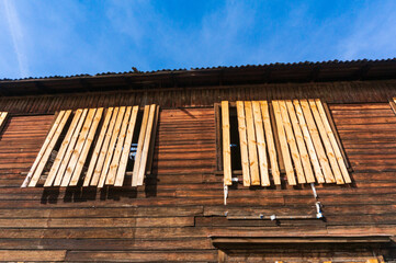 An old wooden, dilapidated house, a barrack, with boarded-up windows, against the backdrop of a...