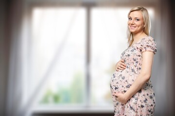 Beautiful pregnant happy woman hugging her tummy