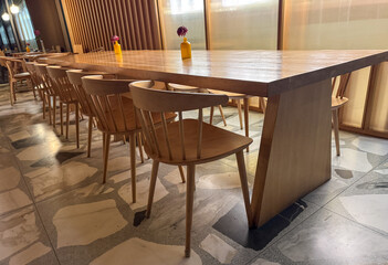 A long wooden table with many chairs around it
