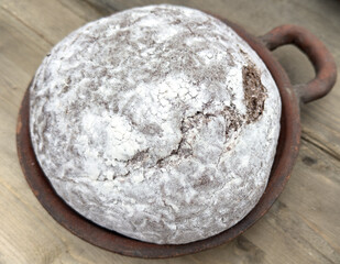 A piece of bread with a white crust sits in a brown bowl