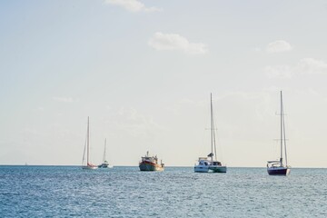 Obraz premium Sailboats anchored in a calm sea under a clear sky.