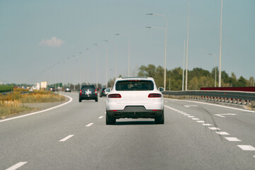 White car traveling down an open road.
