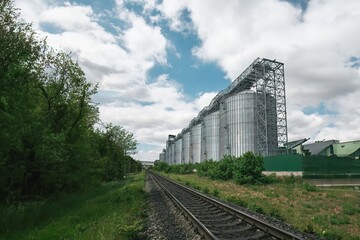 Obraz premium Metal silos and railway under blue sky